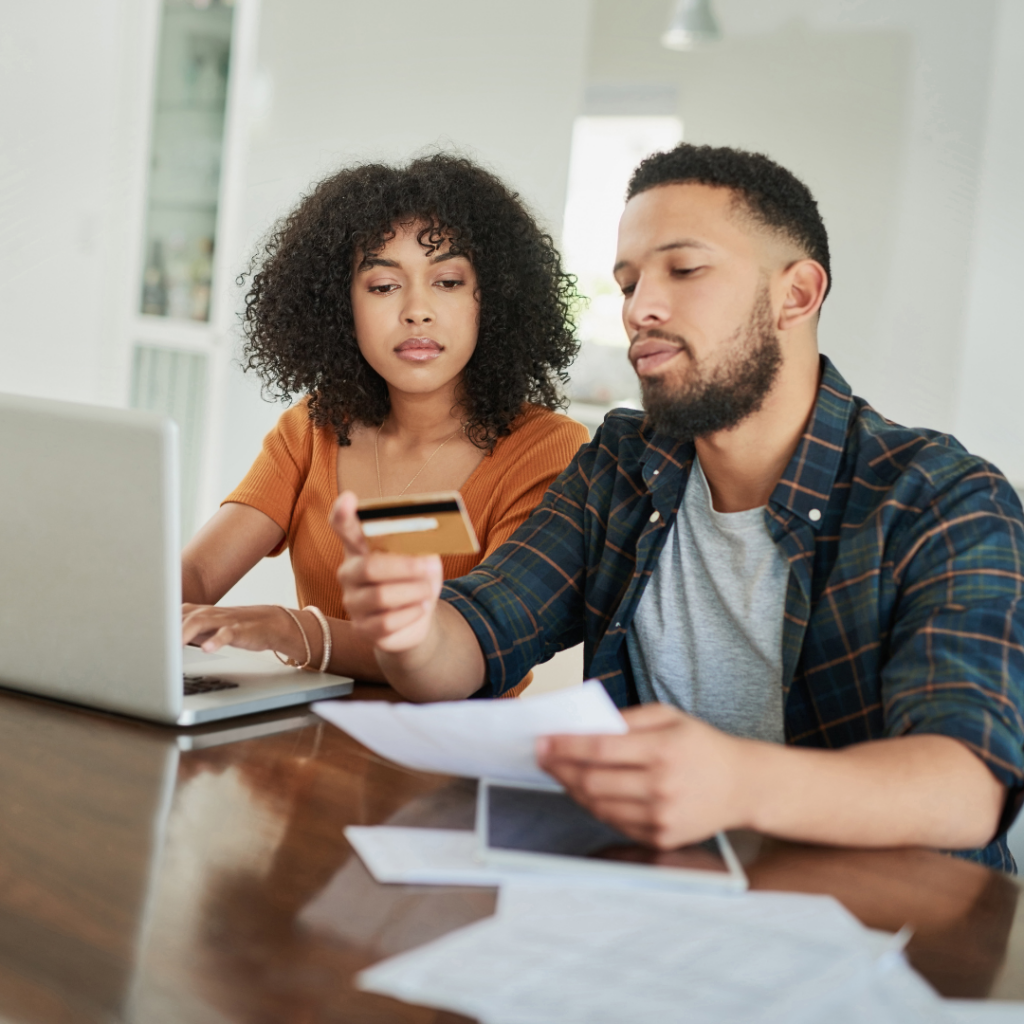 Person reviewing bills at a table with a calculator and notepad, symbolizing debt settlement and financial planning.